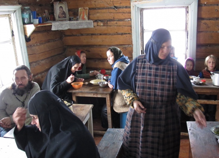 Члены религиозной общины, поселившиеся в заброшенной деревне Черепаново под поселком Ныроб, во время трапезы. Фото: ТАСС/Максим Кимерлинг