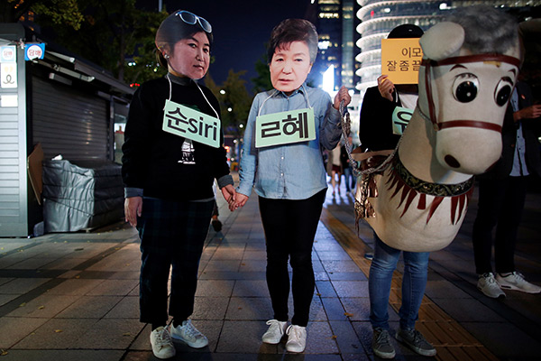 Протестующие в масках Пак Кын Хе и Чхве Сун Силь. Фото: Kim Hong-Ji / Reuters